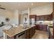 Open kitchen with granite island, stainless steel appliances, and dark wood cabinets at 8234 E Inca St, Mesa, AZ 85207