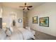 Neutral carpeted bedroom featuring a ceiling fan and access to the ensuite bathroom and walk-in closet at 8234 E Inca St, Mesa, AZ 85207