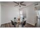 Bright dining area featuring a glass table, four chairs, and a modern ceiling fan for comfortable living at 8787 E Mountain View Rd # 2008, Scottsdale, AZ 85258