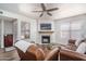 Inviting living room with a cozy fireplace, modern ceiling fan, and comfortable leather seating at 8787 E Mountain View Rd # 2008, Scottsdale, AZ 85258