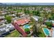 Aerial view of a red roof home with a pool, mature landscaping, a green lawn, and mountain views at 8907 N 85Th Way, Scottsdale, AZ 85258