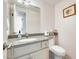 Bathroom featuring a granite-topped vanity, decorative mirror, and a toilet creating a functional and aesthetically pleasing space at 8907 N 85Th Way, Scottsdale, AZ 85258
