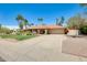 Charming single-story home showcasing a well-manicured lawn, mature palm trees, and a spacious driveway at 8907 N 85Th Way, Scottsdale, AZ 85258