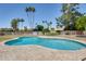 A large swimming pool surrounded by a light colored stone deck is surrounded by a metal safety fence at 8907 N 85Th Way, Scottsdale, AZ 85258