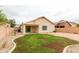 View of the home's exterior and backyard featuring a patio, grass, and rock landscaping at 9319 W Crown King Rd, Tolleson, AZ 85353