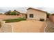 Spacious backyard with desert landscaping, including decorative rock and irrigated green grass at 9319 W Crown King Rd, Tolleson, AZ 85353