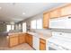 Bright kitchen area with tiled flooring, white appliances, and a view of the living area at 9319 W Crown King Rd, Tolleson, AZ 85353