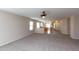 Spacious living room with carpet and a view into the adjacent kitchen and entry at 9319 W Crown King Rd, Tolleson, AZ 85353