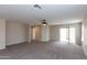 Spacious living room with beige carpet, neutral paint, and sliding glass door to the back at 9319 W Crown King Rd, Tolleson, AZ 85353