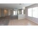 Open-concept living room with neutral colored carpet and a view into the adjacent kitchen at 9319 W Crown King Rd, Tolleson, AZ 85353