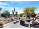 Landscaped backyard with desert plants, seating area and patio at 9621 E Calgary Ave, Sun Lakes, AZ 85248