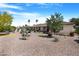 Expansive backyard with desert landscaping, mature trees, and comfortable seating area at 9621 E Calgary Ave, Sun Lakes, AZ 85248