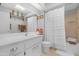 Bright bathroom featuring a white vanity, neutral tile, and shower with textured white curtain at 9621 E Calgary Ave, Sun Lakes, AZ 85248