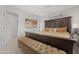 Bedroom with large bed, bench, wall art and carpeting at 9621 E Calgary Ave, Sun Lakes, AZ 85248