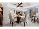 Bright dining area featuring a round glass table, elegant chairs, and shuttered windows at 9621 E Calgary Ave, Sun Lakes, AZ 85248