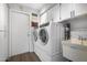 Clean laundry room with modern washer and dryer, storage cabinets, utility sink, and tile floor at 9621 E Calgary Ave, Sun Lakes, AZ 85248