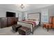 Bright main bedroom with decorative chandelier, accent furniture, and plantation shutters at 9621 E Calgary Ave, Sun Lakes, AZ 85248