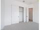 Bright bedroom with gray carpet, white walls, closet, and paneled door to the hallway at 10022 S 37Th Ave, Laveen, AZ 85339