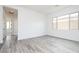 Light-filled bedroom with wood-look tile flooring, white walls, and a window overlooking an enclosed yard at 10022 S 37Th Ave, Laveen, AZ 85339