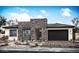 Modern single-story home featuring a stone facade, neutral stucco, and a two-car garage at 10022 S 37Th Ave, Laveen, AZ 85339