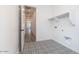 Neat laundry room features stylish patterned tile flooring, storage shelving and washer/dryer hookups at 10022 S 37Th Ave, Laveen, AZ 85339