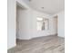 Bright living room featuring wood-look tile flooring, white walls, and a window overlooking an enclosed yard at 10022 S 37Th Ave, Laveen, AZ 85339