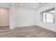 Bright living room with an open floor plan, white walls and light wood-look tile flooring at 10022 S 37Th Ave, Laveen, AZ 85339