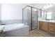 Modern bathroom with a soaking tub, glass-enclosed shower, and double vanity at 10022 S 37Th Ave, Laveen, AZ 85339