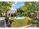 Landscaped backyard featuring a sparkling pool, lush grass, and mature trees at 108 E Horseshoe Ave, Gilbert, AZ 85296