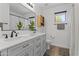 Contemporary bathroom features a double sink vanity with wood accents, plus large mirror and plant at 108 E Horseshoe Ave, Gilbert, AZ 85296