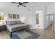 Well-lit bedroom with a bed, nightstands, minimalist decor, and doorway to an ensuite bathroom at 108 E Horseshoe Ave, Gilbert, AZ 85296