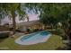 Beautiful backyard with a sparkling private pool, lush green lawn, and mature trees at 108 E Horseshoe Ave, Gilbert, AZ 85296