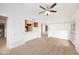 Spacious living room with neutral carpet, ceiling fan, and an open concept kitchen at 1333 E Morten Ave # 230, Phoenix, AZ 85020