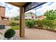 View of the brick-paved backyard patio featuring a small grass lawn and lush greenery, perfect for outdoor enjoyment at 1350 S Greenfield Rd # 1125, Mesa, AZ 85206