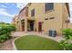 This property features a well-manicured backyard with brick paving, a small lawn, and shade from the covered patio at 1350 S Greenfield Rd # 1125, Mesa, AZ 85206