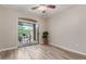 Bedroom with wood-look flooring, ceiling fan, and sliding glass door leading to the home's outdoor patio at 1350 S Greenfield Rd # 1125, Mesa, AZ 85206