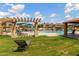 Lounge by the sparkling community pool with pergola-shaded seating, lush landscaping, and sunny skies overhead at 1350 S Greenfield Rd # 1125, Mesa, AZ 85206