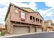 Charming home exterior showcasing stone accents, multiple garage doors, and cozy upper-level balconies at 1350 S Greenfield Rd # 1125, Mesa, AZ 85206