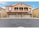 Inviting exterior view of a multi-story home featuring three garage doors and charming balconies at 1350 S Greenfield Rd # 1125, Mesa, AZ 85206