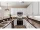 Modern kitchen features stainless steel appliances, granite counters, and white cabinetry with dark, wood-style floors at 1350 S Greenfield Rd # 1125, Mesa, AZ 85206