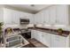 Bright kitchen with stainless steel appliances, dark granite counters and matching backsplash, plus sleek white cabinets at 1350 S Greenfield Rd # 1125, Mesa, AZ 85206