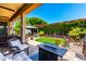 Outdoor oasis with a patio set, gazebo, lush landscaping, and a fire pit at 1361 N Claiborne --, Mesa, AZ 85205