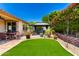 Beautiful backyard featuring a gazebo, artificial grass, brick landscaping, and an outdoor dining table at 1361 N Claiborne --, Mesa, AZ 85205