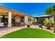 Backyard featuring artificial grass, brick landscaping, patio dining table, and a gazebo at 1361 N Claiborne --, Mesa, AZ 85205