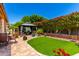 Beautiful backyard features a gazebo, artificial grass, brick landscaping, and lush plants at 1361 N Claiborne --, Mesa, AZ 85205