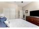 This bedroom features a queen-sized bed, a dresser with a TV, and double door closet at 1361 N Claiborne --, Mesa, AZ 85205