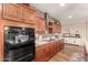 Eat-in kitchen featuring granite counters, wooden cabinetry, modern appliances, and tile backsplash at 1361 N Claiborne --, Mesa, AZ 85205
