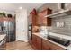 Updated kitchen with stainless steel appliances, tiled backsplash, granite counters, and wooden cabinets at 1361 N Claiborne --, Mesa, AZ 85205