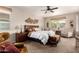 Cozy main bedroom with ceiling fan, large bed, and seating area at 1361 N Claiborne --, Mesa, AZ 85205