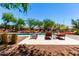 Sparkling community pool with lounge chairs, surrounded by lush landscaping and community buildings at 1361 N Claiborne --, Mesa, AZ 85205